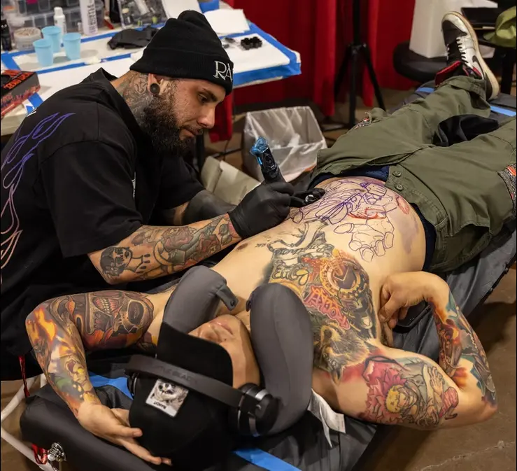 Tattoo artists working live at the expo